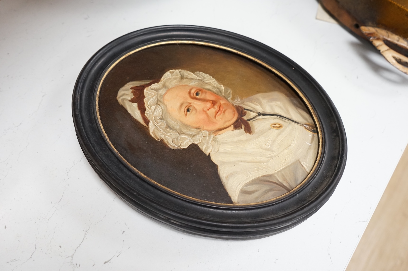 Georgian School, portrait of a lady wearing a bonnet, unsigned, oval oil on panel, 26 x 20cm, housed in an ebonised frame